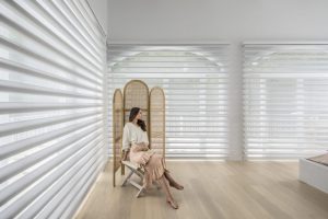 A room with wooden flooring is perfect with a a white Pirouette Shadings designed by Katandra Interiors Busselton.