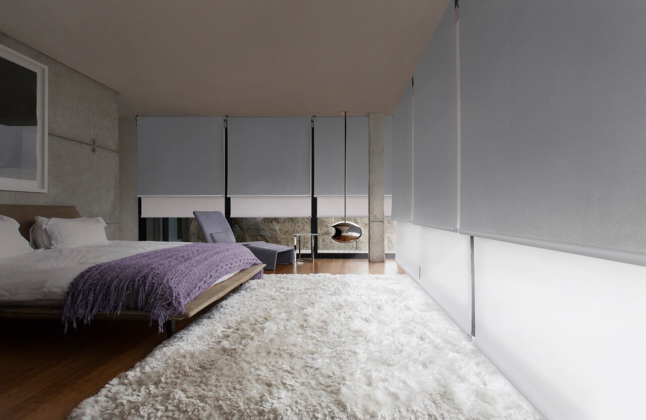 A bedroom with wooden flooring and white carpet, a glass window with gray and white Duette Shades Installed by Katandra Interiors Busselton.