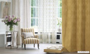 An extra long white curtain and sheer, a vertical-striped chair with pillow, and a table with flower vase masterpieced by Katandra Interiors Busselton.